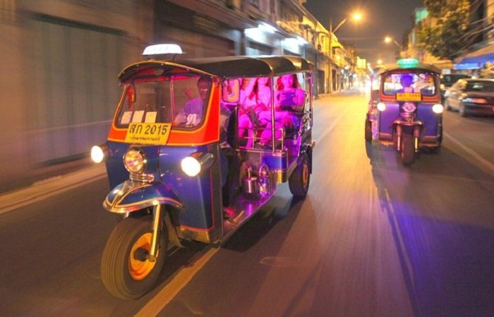 Tourists riding colorful Tuk Tuks